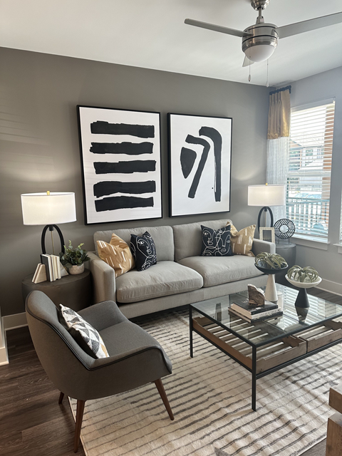 a living room with a grey couch and a glass coffee table